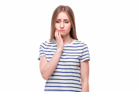 Sad girl with dental tooth pain on white background.の写真素材