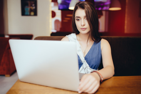 Casual woman using laptop at coffee shopの写真素材