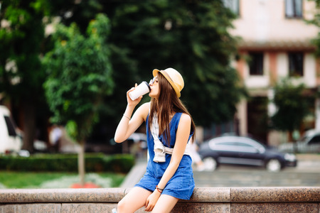 Nice beauty girl with take out coffee in city squar. Urban life concept.の写真素材