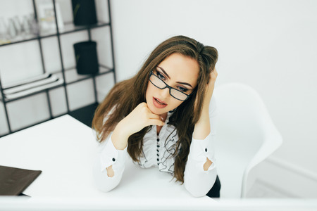 Young pretty business woman with glasses work in computer in the officeの写真素材