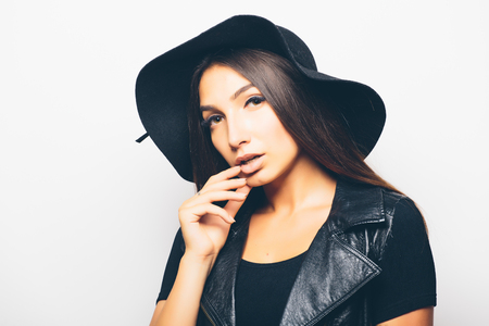 beautiful fashion mulatto girl wearing sunglasses and black hat over a white background.の写真素材