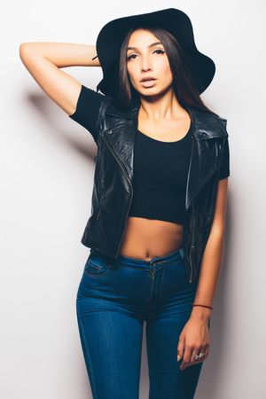 beautiful fashion mulatto girl wearing sunglasses and black hat over a white background.の写真素材
