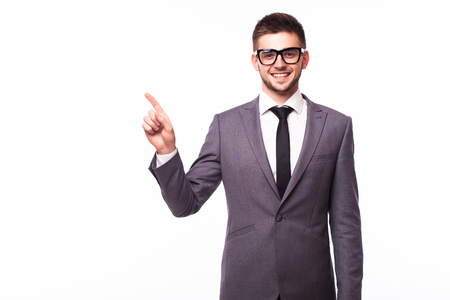 Handsome smiling businessman pointing finger away over gray backgroundの写真素材