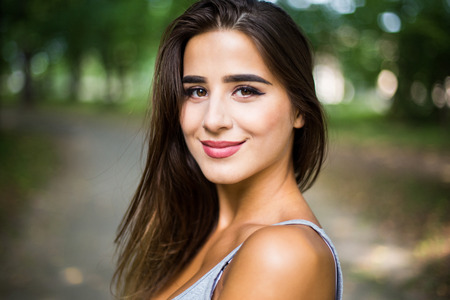 Outdoors portrait in park of a beautiful tanned teen student girl.の写真素材