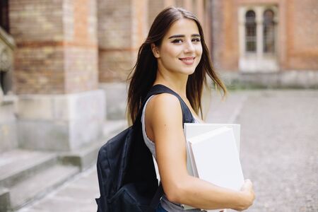 smiling female student in black eyeglasses with foldersの写真素材