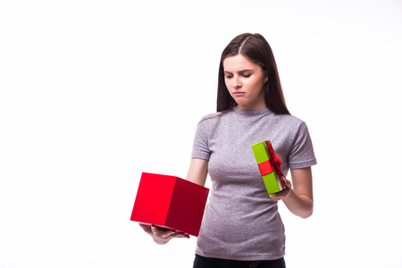 Cheerful young woman opening present box isolated on a white backgroundの写真素材