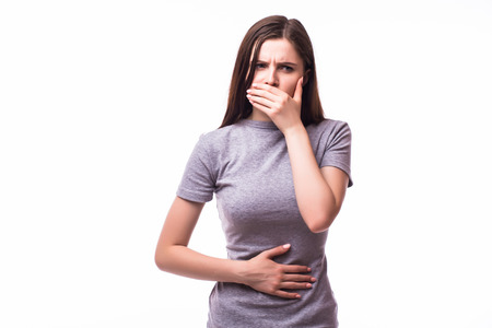 Closeup portrait of young unhappy, annoyed, sick woman about to chuck, throw up, retch barf, hurl isolated on white background.の写真素材