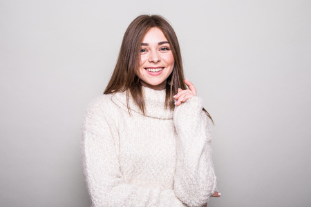 Pretty model in sweater in studio isolated gray background