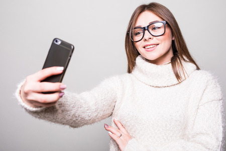Woman make selfie wearing in white sweaterの写真素材