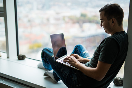 handsome modern man designer working home using laptop at homeの写真素材
