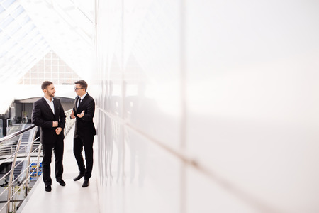 business partners walking down in office building and talking