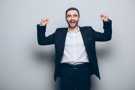 Young businessman in suit raised hands isolatedの写真素材