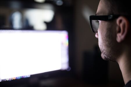 Programer face over white monitor screen on backの写真素材