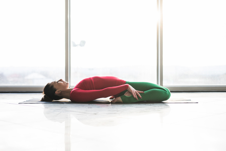 Beautiful yoga woman practice in a big window hall background. Yoga concept.