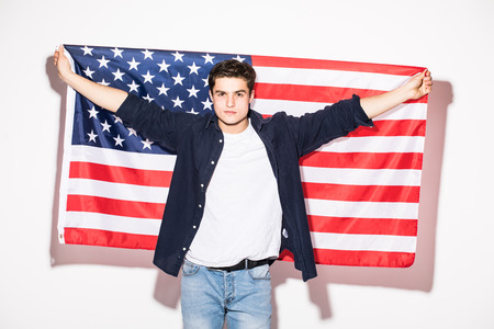 Young man with US flag in hands on white. USA Patriotism.の写真素材