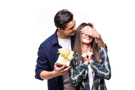 Couple gift share. Young man make a surprise for his girlfriend. Man close with hands woman eyes.の写真素材