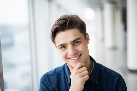 handsome young man smiling indoors in office hallの写真素材