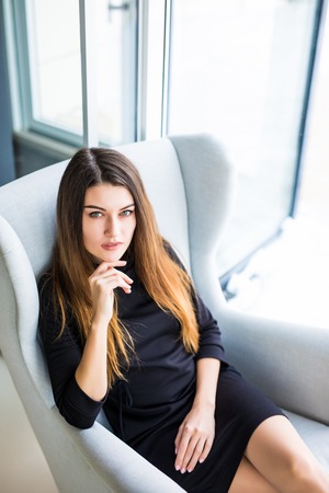 Attractive young woman sitting on a chair in a cafe