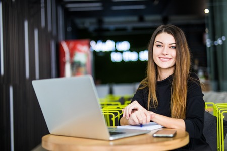 Happy smiling woman working with laptop in officeの写真素材