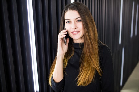 Portrait of a young woman talking on mobile phoneの写真素材