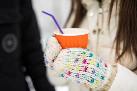 Happy couple drinking hot tea in winter parkの写真素材