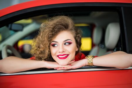 Young woman in her new car smiling.の写真素材