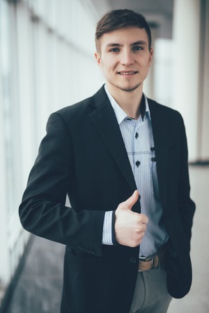 young business man going thumb up the officeの写真素材