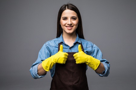 Cleaner woman thumbs up with yellow glovesの写真素材