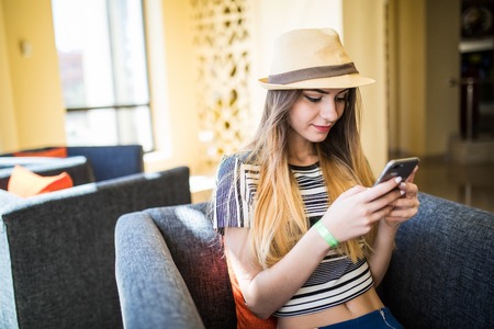 Portrait Of Happy Young Woman Reading a Message With Cellphoneの写真素材