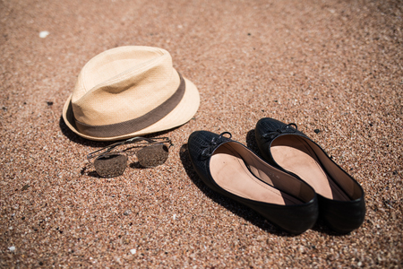 Summer hat, shoes and sunglasses on sea sand.の写真素材