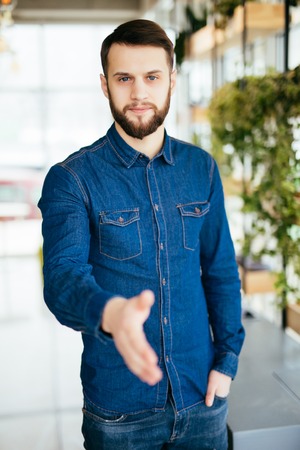 HandShake, Casual Bearded Man Wear Checked Blue Shirt Hold Hand Shake Greeting Over White Brick Wallの写真素材