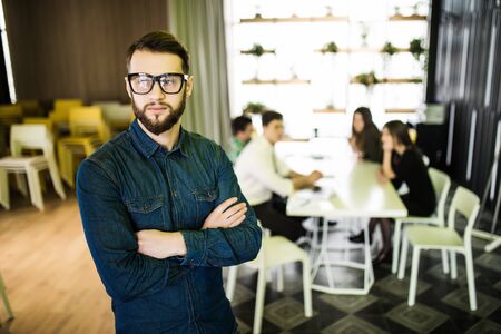 Portrait of businessman with colleagues in meeting in background at the office