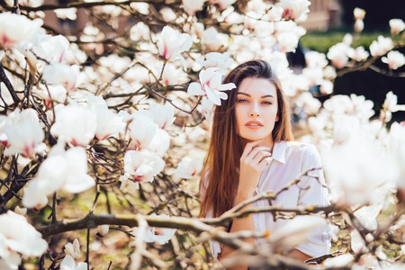 Head portrait of beautiful woman with magnolia flowersの写真素材