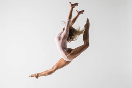 young modern ballet dancer jumping on white