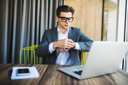 Handsome businessman working with laptop in officeの写真素材
