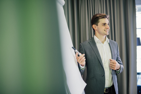 portrait of a confident businessman making presentation on flipchartの写真素材