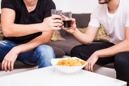 Two friends having a glass of whiskey and some quality time togetherの写真素材