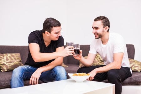 Two friends having a glass of whiskey and some quality time together at homeの写真素材