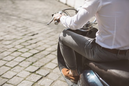 Driving fast. Close up portrait of young man driving scooter on street.の写真素材