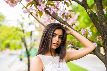 Girl with sakura tree flowers. Focus on face.の写真素材