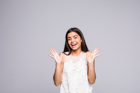 Young beautiful woman with facial expression of surprise standing over gray background. Looking at the cameraの写真素材