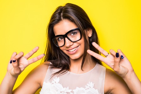 Young girl wearing eyeglasses in yellow background. Girl looking at camera.の写真素材