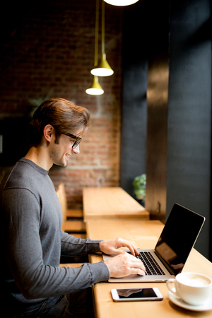 A man in a cafe with coffee and laptopの写真素材