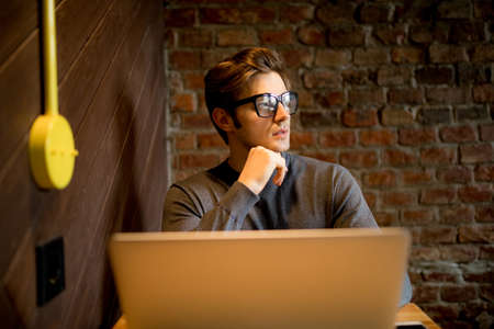 Happy man drinking coffee and working on laptopの写真素材