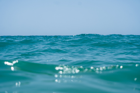 Blue marin clear ocean water with waves and sky with clouds. shot from water. Summer timeの写真素材