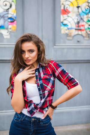 Young girl in stylish clothes posing in the city streetの写真素材