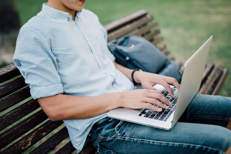 Detail of man s hand while working with laptop in a parkの写真素材