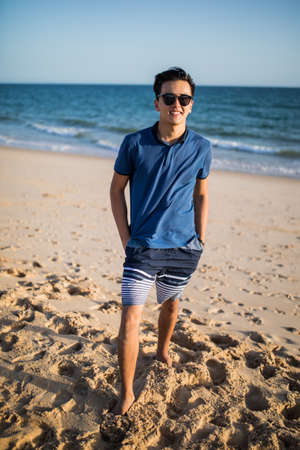 Relaxing and smiling young man on the beachの写真素材