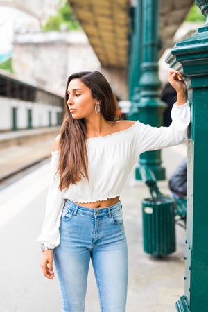 Young woman posing at platform on train station. Waiting a trainの写真素材