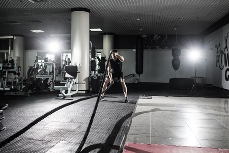 Fitness man working out with battle ropes at gym. Battle ropes fitness man at gym workout exercise...
